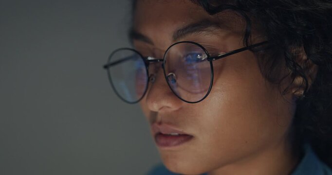 Close-up Black female programmer with code reflection in glasses working late in home office at night. Cybersecurity, AI algorithm, Network security, software developer, serious face, burnout concept.