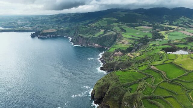 Agricultural countryside on volcanic Atlantic coast with green fields in Sao Miguel Island, Azores, aerial view