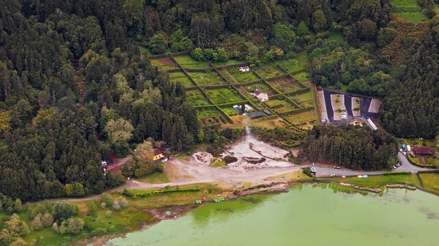 Geothermal fumaroles near Lagoa das Furnas on Sao Miguel island, Azores. Steam rising from volcanic ground by lake shoreline. Aerial view