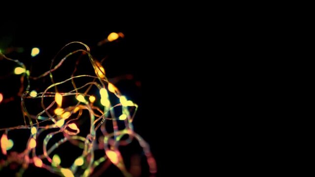 Close-up view of tangled colorful fairy lights glowing warmly against a pure black background. Concept of festive celebrations, holiday magic, and cozy decorative lighting.