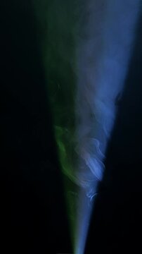 Projector light ray piercing atmospheric smoke, building dramatic volumetric glow against dark background.
