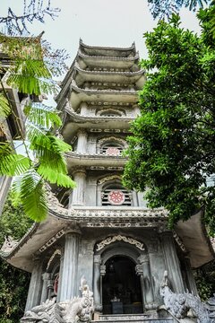 DA NANG, VIETNAM - APRIL 15, 2026:Low angle view of the historic Xa Loi tower pagoda surrounded by green trees at the Marble Mountains in Da Nang Vietnam