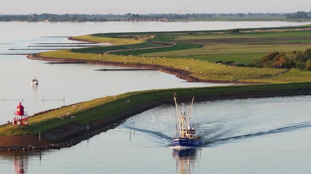 Fishing trawler sailing through a scenic harbor channel