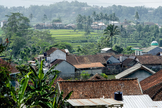 Scenic view of a traditional village in indonesia with rice terraces and lush tropical landscape in the background