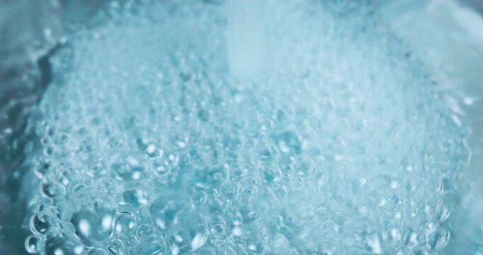 Acqua che scorre  in un contenitore di vetro formando bolle d'aria