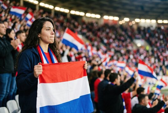 Paraguayan football fan holding flag in crowded stadium