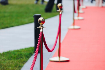 Naklejka premium Red carpet on a movie premiere, cinema film festival event, ropes and golden barriers on a luxury party entrance, awards gala ceremony, wealthy rich guests arriving, outdoor venue decoration elements