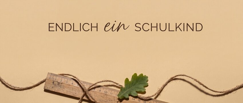Einschulung Schulkind back to school flat lay background with vintage wooden ruler, natural oak leaf, jute twine, German text greeting for first day of school class, minimalist conceptual banner card.
