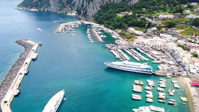 Cinematic aerial view of Capri Marina Grande with boats and coastal scenery