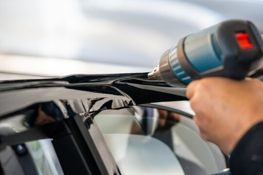 A car wrapping specialist applies a polyurethane film to the car. Detailer PPF