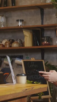 Vertical Screen : Young Asia female wear face mask self service use mobile phone pay contactless at restaurant. Girl barista talking receive order from customer at cafe. Lifestyle after corona virus.