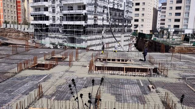 High-angle horizontal view of a real estate construction zone detailing an extensive layout of steel rebar mesh and deep foundation groundwork.