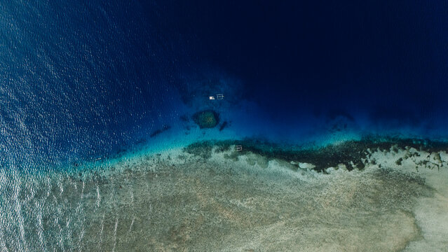 Drone view of coral reef and deep blue ocean in tropical waters