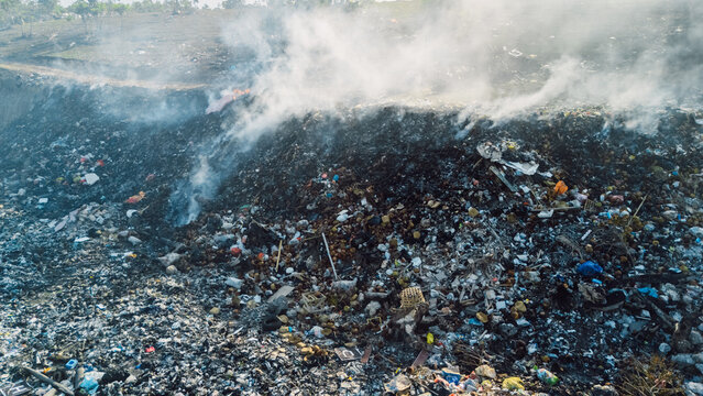 Burning landfill with smoke and waste environmental pollution
