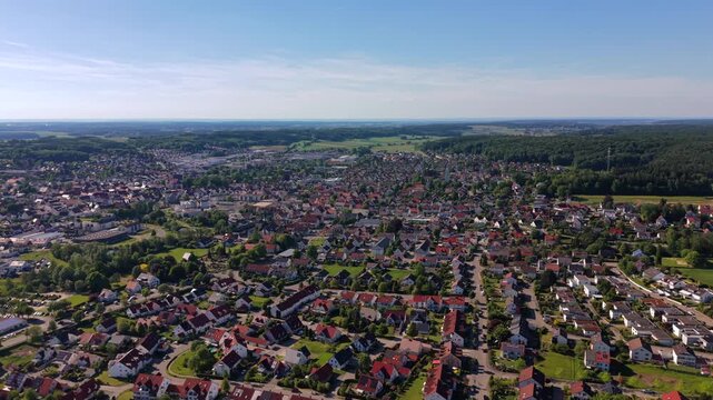 High angle view of Krumbach, Bavaria. Drone footage showcasing the historic urban architecture surrounded by green trees, streets and fields in Germany.
