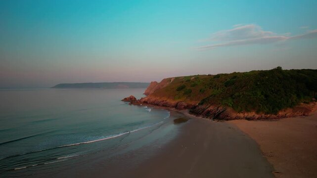 Sunrise at Three Cliffs Bay in Wales. Drone flight