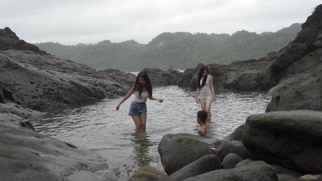 Friends Exploring Natural Tide Pool on Rocky Beach Indonesia