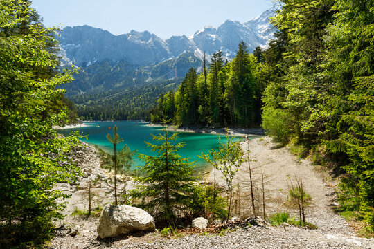 Travel landscape of Eibsee lake and Zugspitze mountains peak Alps in Bavaria Germany, scenic summer nature panorama with forest and beach