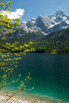 Travel landscape of Eibsee lake beach and Zugspitze peak in Alps, Bavaria, Germany, scenic summer nature panorama with forest