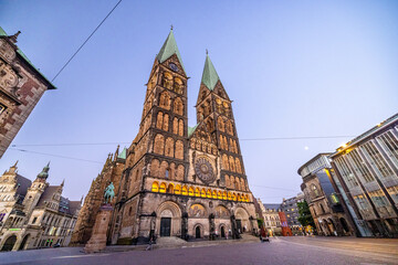 Fototapeta premium Bremen by night, with glowing streets, historic facades, and reflections creating a peaceful urban atmosphere in the heart of northern Germany.