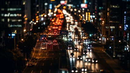 Obraz premium A long-exposure capture of highway traffic at night, showing blurred light trails from moving vehicles against a backdrop of city buildings