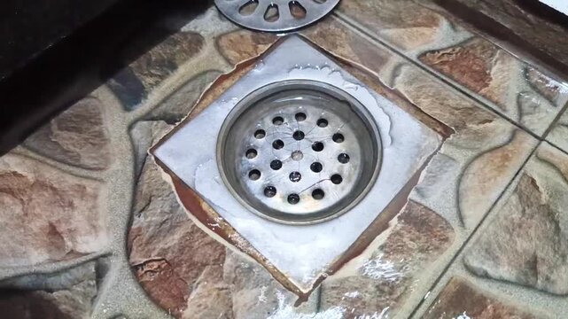 The metal bathroom floor drain was clogged with hair.