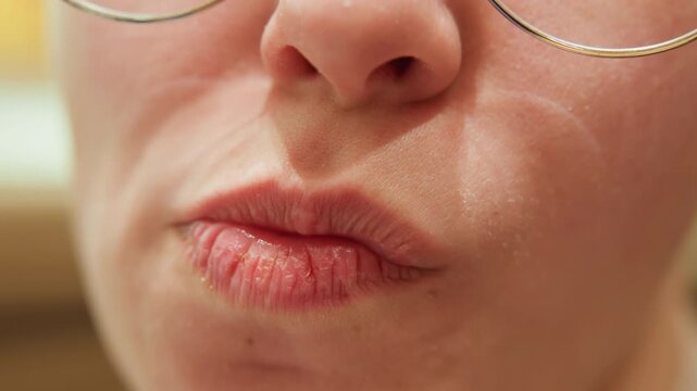 Closeup caucasian storyteller speaking and laughing, lips move from pursed kiss to open speech and to smile, glasses rim visible, dynamic mouth articulation, candid warm scene suggesting rehearsal
