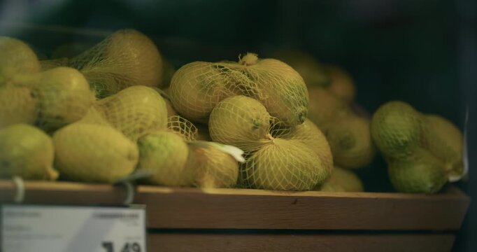 Lemons in protective net packaging displayed in a wooden crate at a store in Zagreb Croatia.