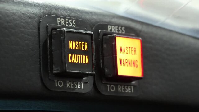 Flashing warning lights alert pilots of a serious problem with the aircraft. Master Warning, Master Caution switch lights in a safety and troubleshooting system. Operator pushes lights to extinguish 