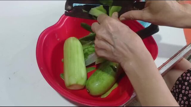 Hands Peeling Winter Melon with Knife for Cooking in Rural Vietnam