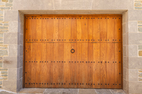 Traditional wooden gate set within stone masonry facade in Rupit village, Catalonia, Spain