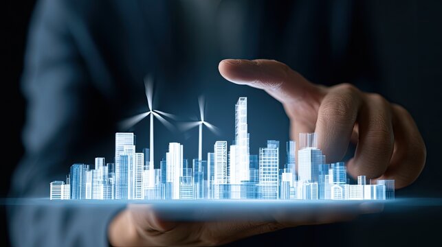 A hand manipulates a glowing holographic cityscape with wind turbines