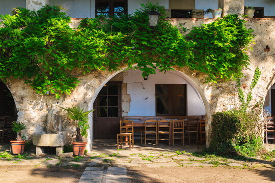 Historic Mediterranean courtyard with stone arches and rustic outdoor dining area