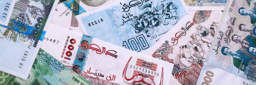 Algerian dinar money bills pile on table. Algeria banknotes of DZD currency close up.