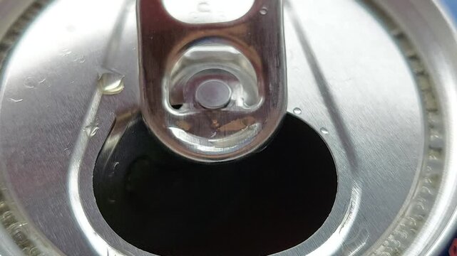 Macro top view of opening an aluminum beverage can