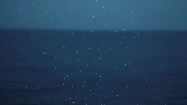Bioluminescent glowing particles drifting through deep dark ocean currents creating a mesmerizing underwater animation sequence featuring ethereal light trails and shimmering bubbles for a cinematic v