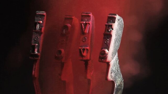 The word love with retro typewriter hammers and red smoke 
