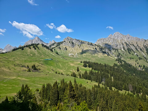 Austria, Rugged alpine cliffs casting beautiful shadows across forests valleys and vibrant mountain meadows