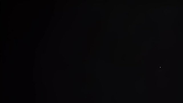 Fireworks bursting with bright white light streaks across the dark night sky in this mesmerizing motion video footage capturing a beautiful celebration display of pyrotechnics exploding in the black a