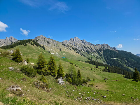 Austria, Charming alpine mountain hut nestled below dramatic rock formations and magnificent Hahnenkamm scenery