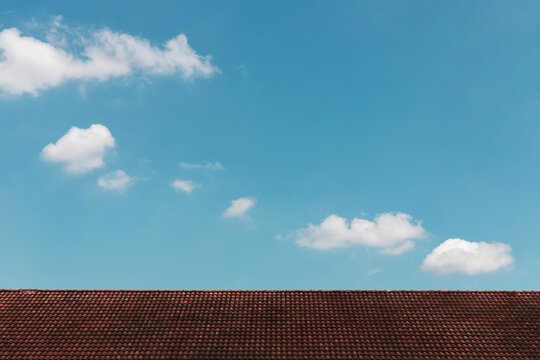 Clouds in the Blue Sky on Sunny Day over Red rooftop