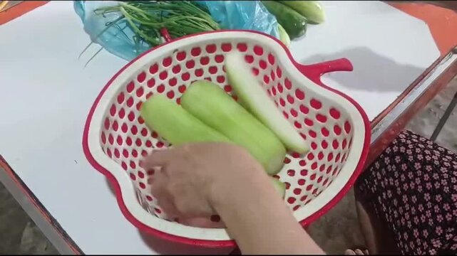 Hands Slicing Winter Melon into Thin Strips for Cooking in Rural Vietnam