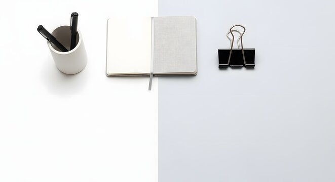 Minimalist desk office supplies arrangement on split background color with ample lower copy space.