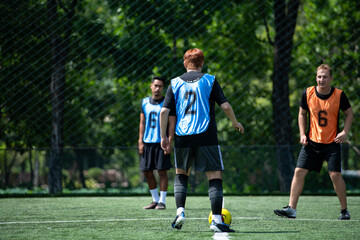 Fototapeta premium Soccer coach leading a practical training drill with players on an outdoor football field