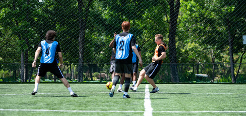 Naklejka premium Soccer coach leading a practical training drill with players on an outdoor football field