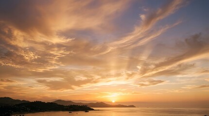 Fototapeta premium Serene sunset over calm ocean waters with silhouetted mountains and coastal town