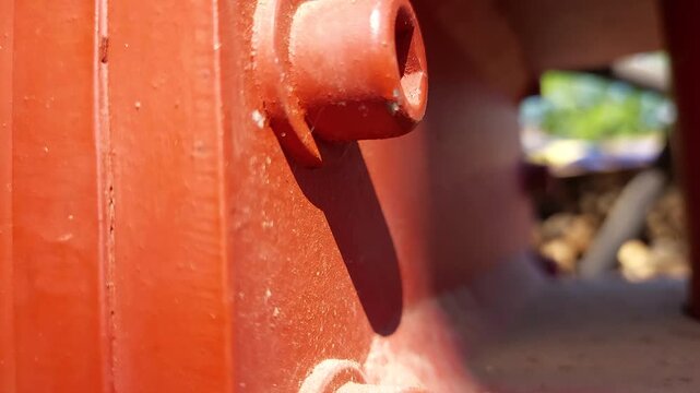 Extreme close up of red painted allen socket head cap screws on industrial equipment
