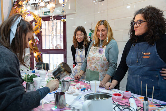 Women learning craft during candle making workshop