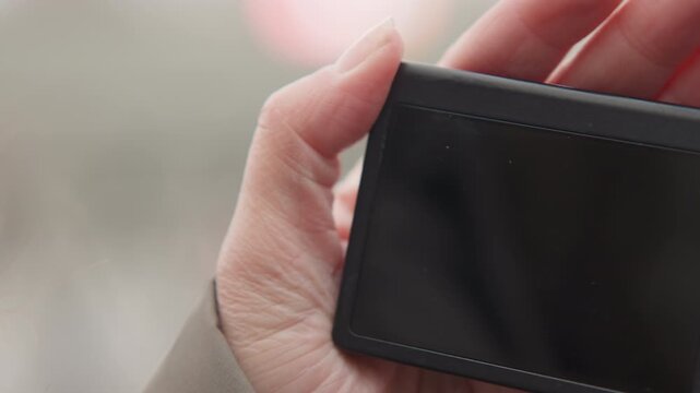 Closeup caucasian hands flipping lcd screen to review shots, photojournalist navigating menu and thumbnails, inspecting image gallery and settings outdoors, methodical playback for storytelling