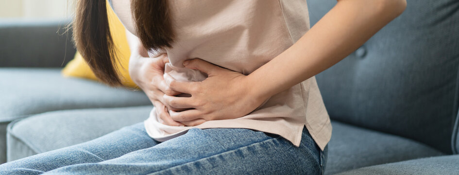 asian young woman intolerance hand in stomach ache, suffer from food poisoning, abdominal pain and colon problem